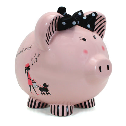 Miss Madeleine pink ceramic piggy bank with black polka dot bow, girl walking poodle illustration, striped feet and ears