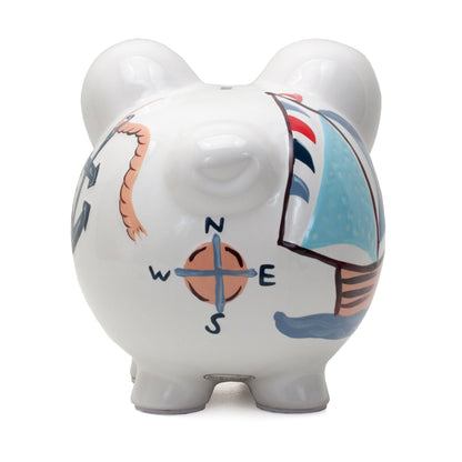 Back view of white piggy bank showing handpainted compass, anchor and ropes
