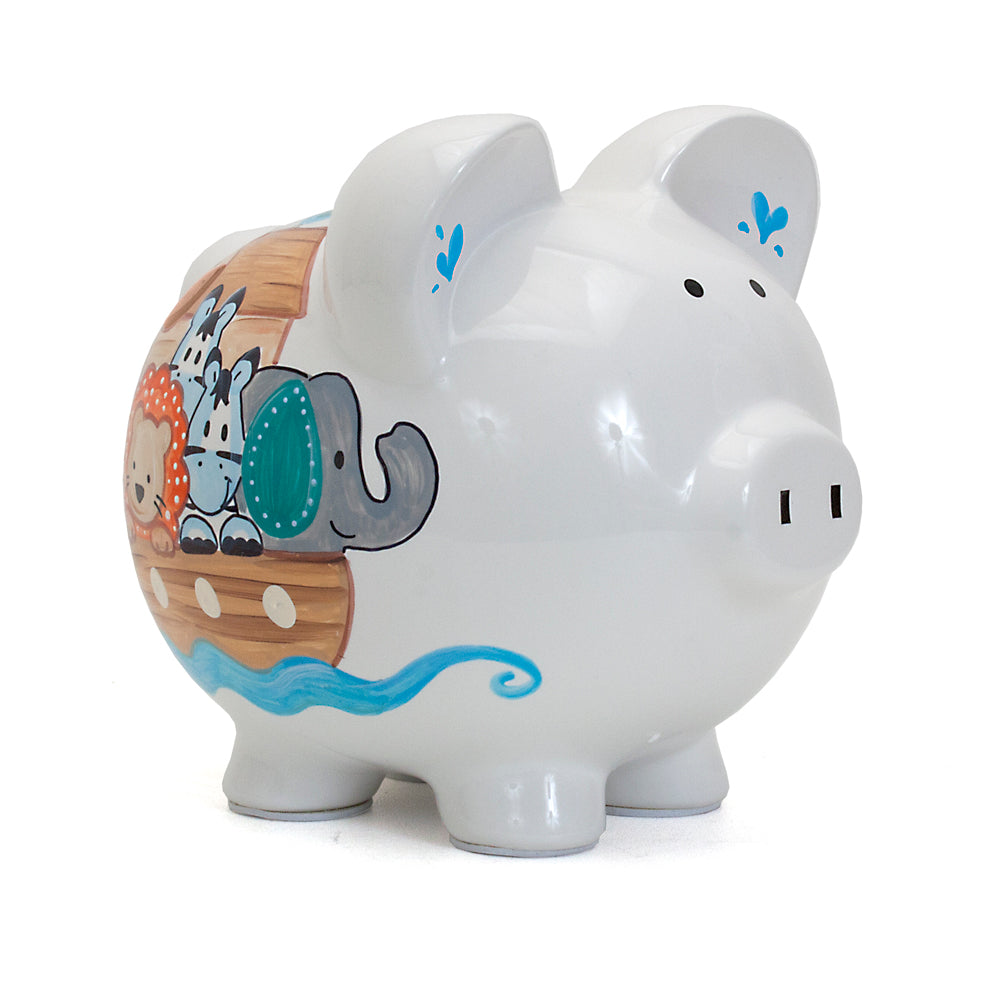White ceramic piggy bank with handpainted Noah's Ark animals featuring lion, zebra, and elephant on boat side view