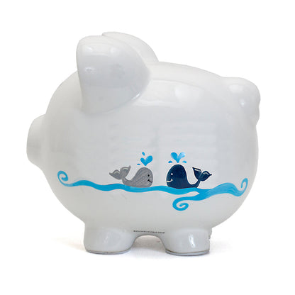 White ceramic piggy bank side showing handpainted blue whales and waves