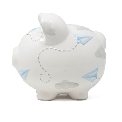 Left rear angle of piggy bank with paper airplane and cloud design on white ceramic surface