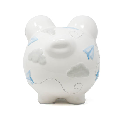 Back view of white ceramic piggy bank featuring blue paper airplanes and gray clouds