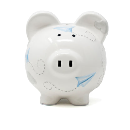 Front view of white piggy bank with black eyes and handpainted paper airplanes in blue and gray clouds