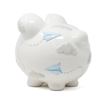 Right side view of white ceramic piggy bank with paper airplane and cloud motifs