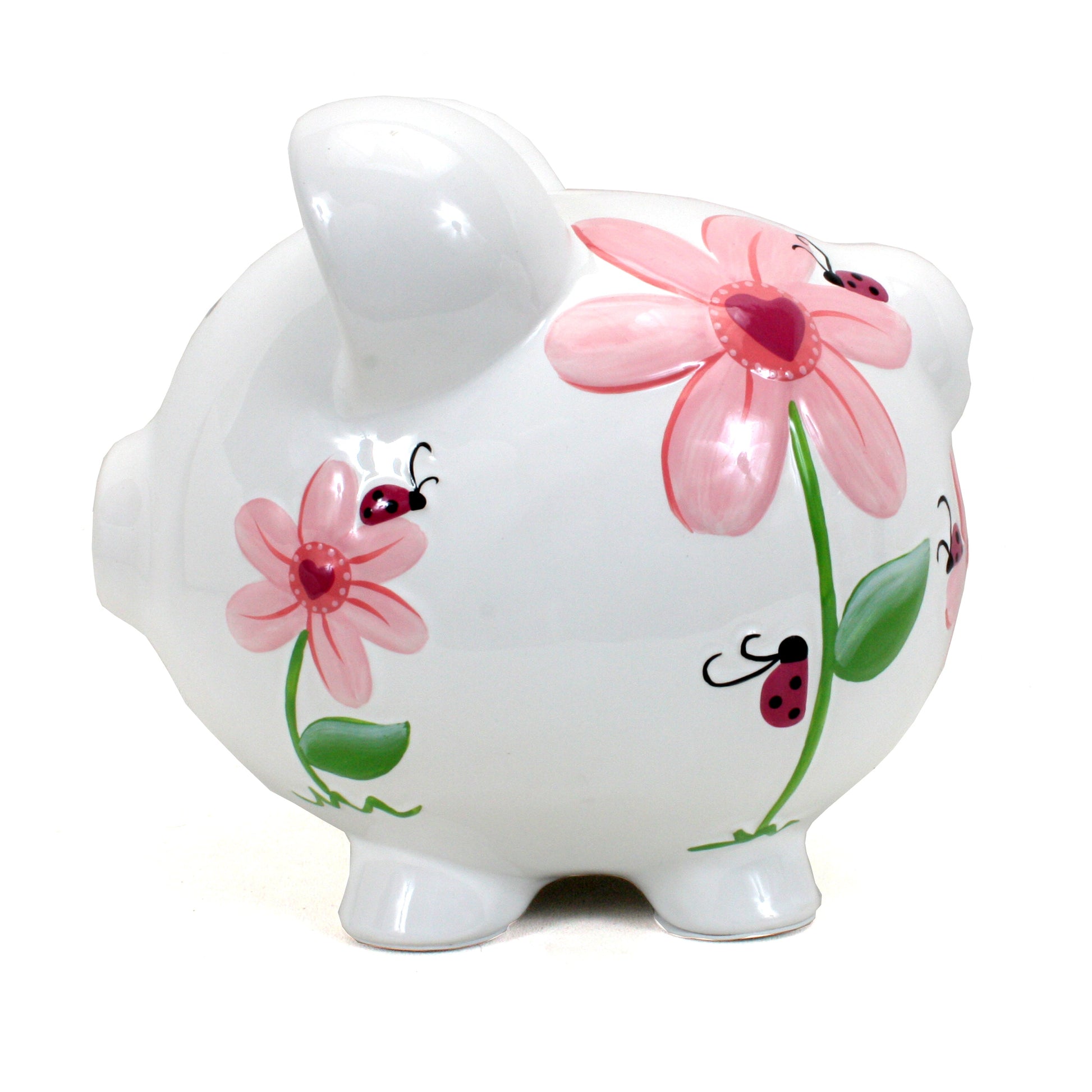 Left side angle of white ceramic piggy bank with colorful ladybug and flower artwork