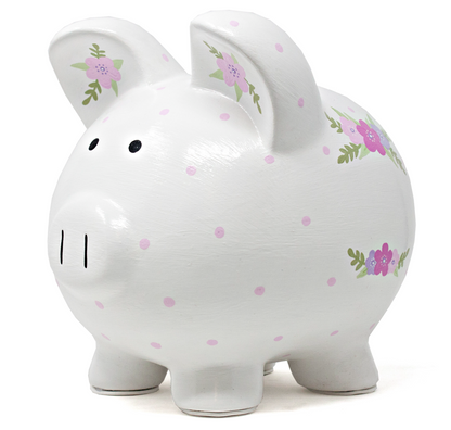 White piggy bank with pink polka dots and floral handpainted details, front left angle