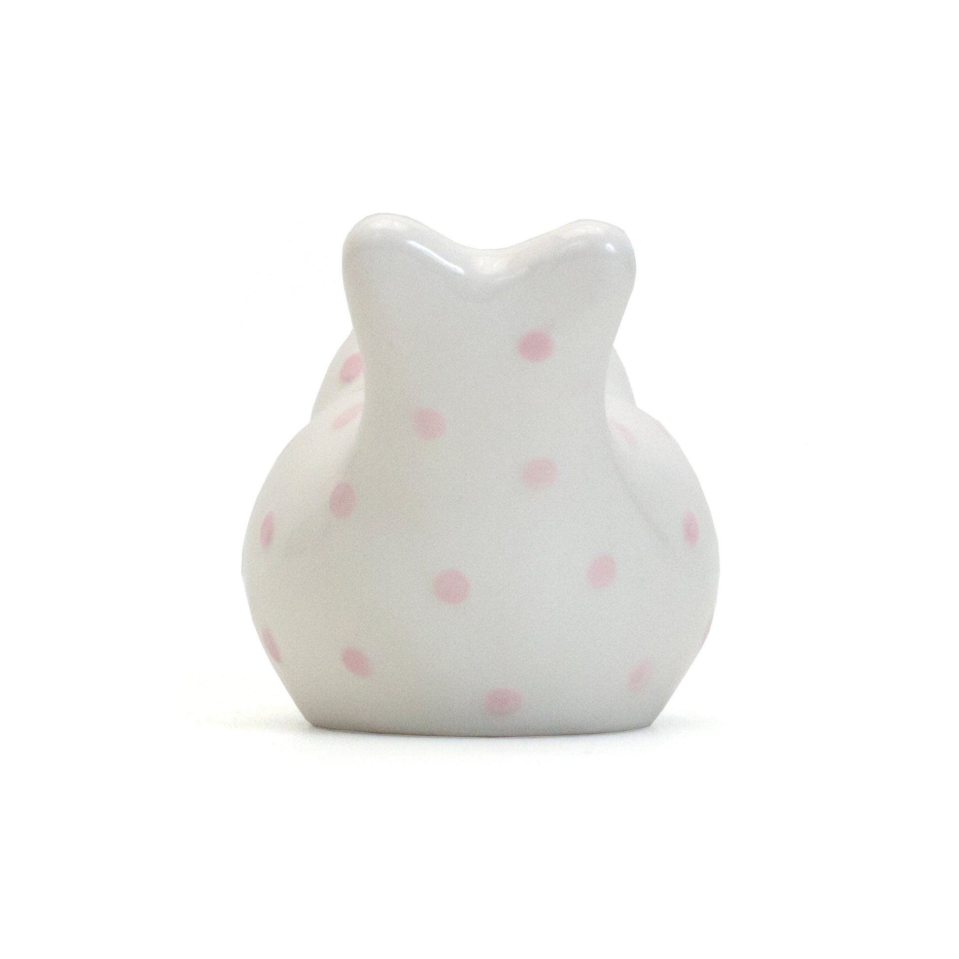 Back view of white ceramic bird piggy bank showing pink polka dots