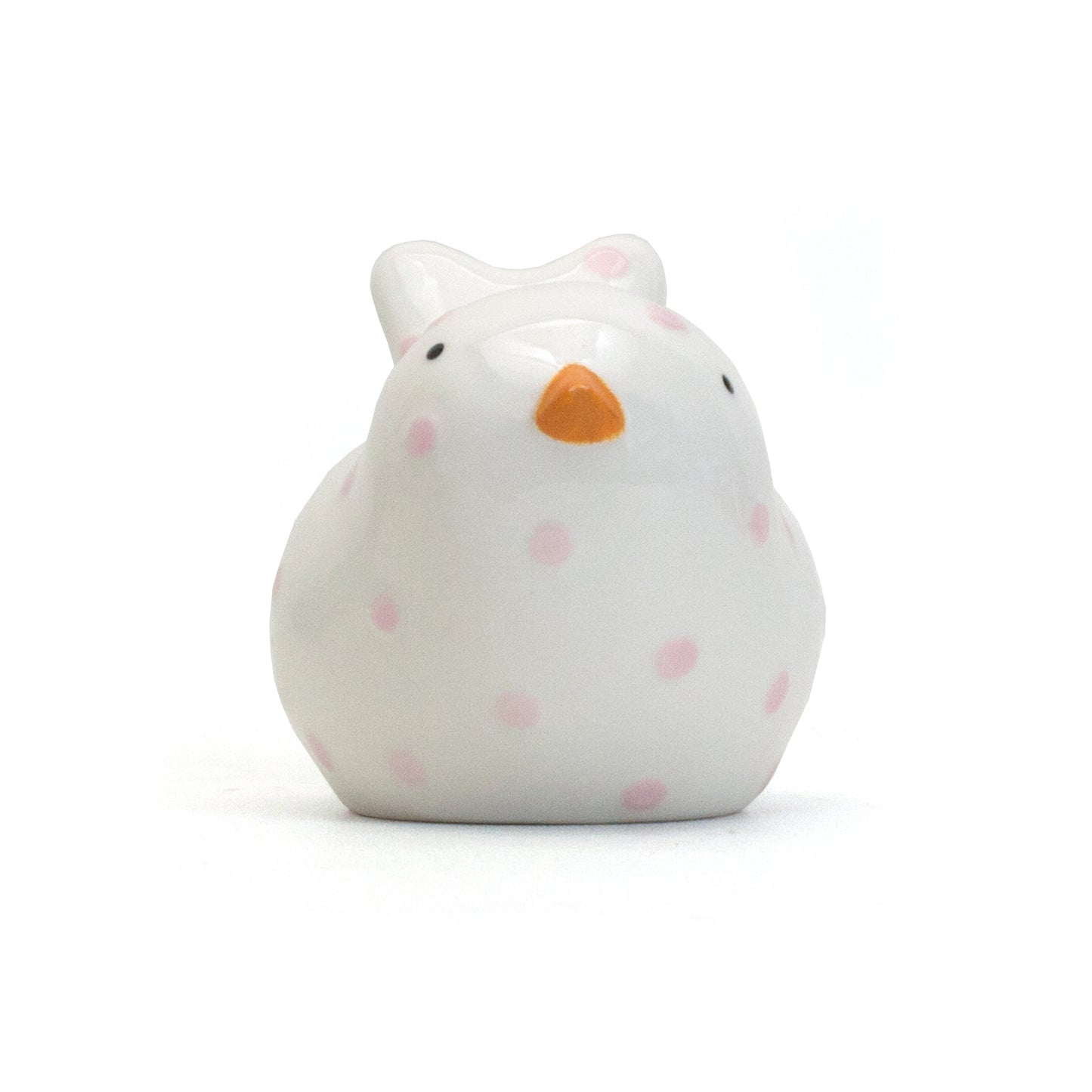 Front view of white ceramic bird piggy bank with orange beak and pink polka dots