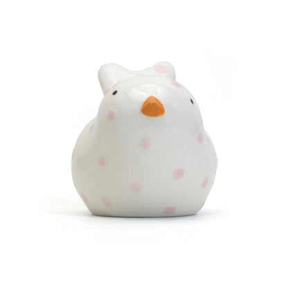 Front view of white ceramic bird piggy bank with orange beak and pink polka dots