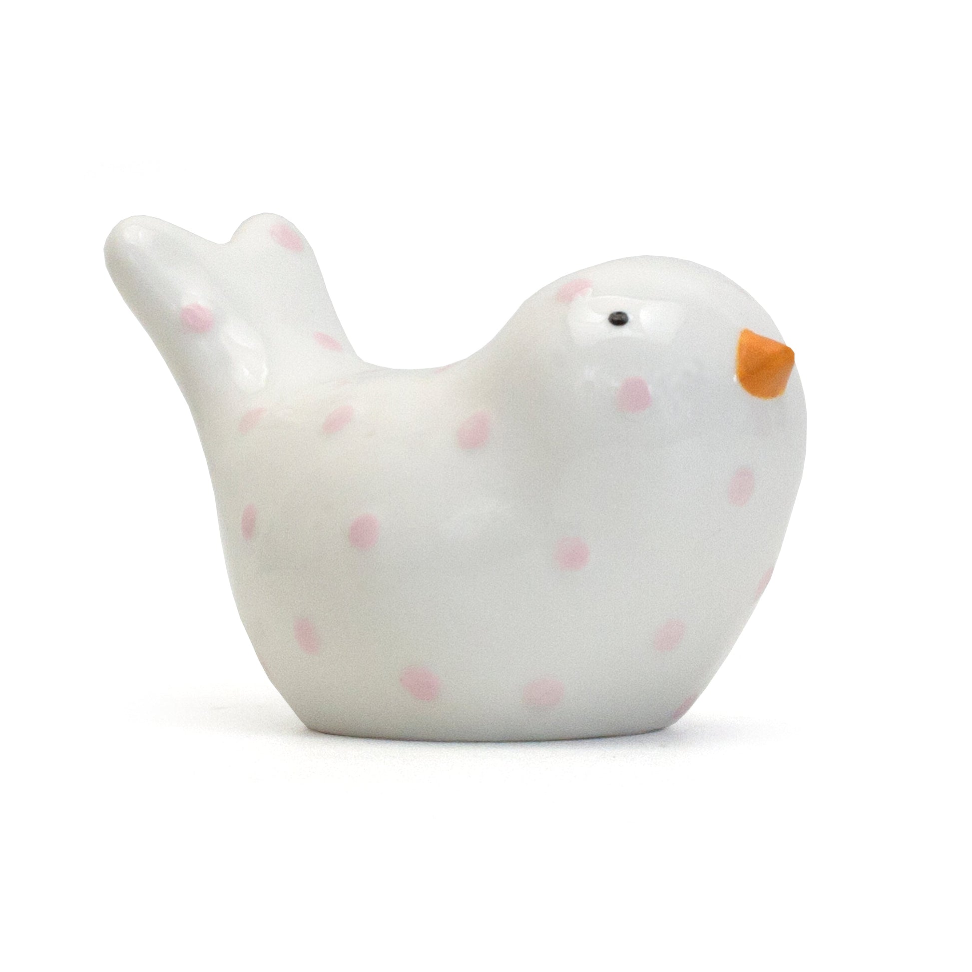 Side view of white ceramic bird piggy bank with pink polka dots and orange beak