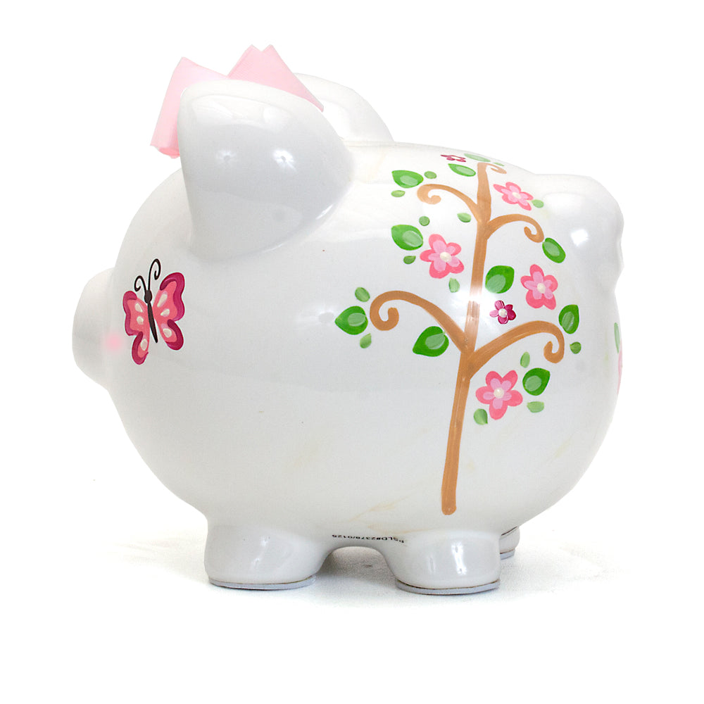Side angle view of owl piggy bank with pink bow showing coin slot on top