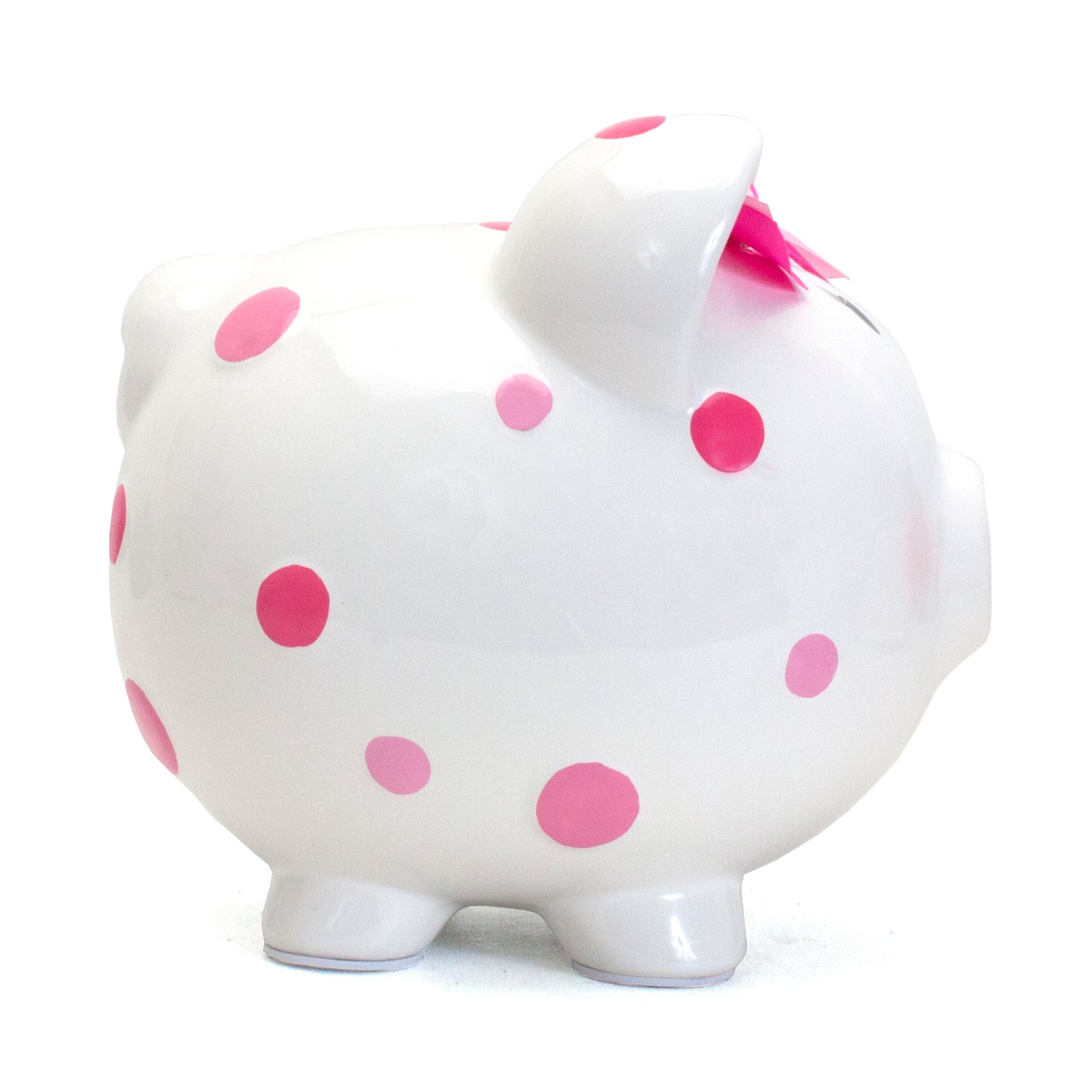 Side profile of white piggy bank showing pink polka dots and pink bow on ear