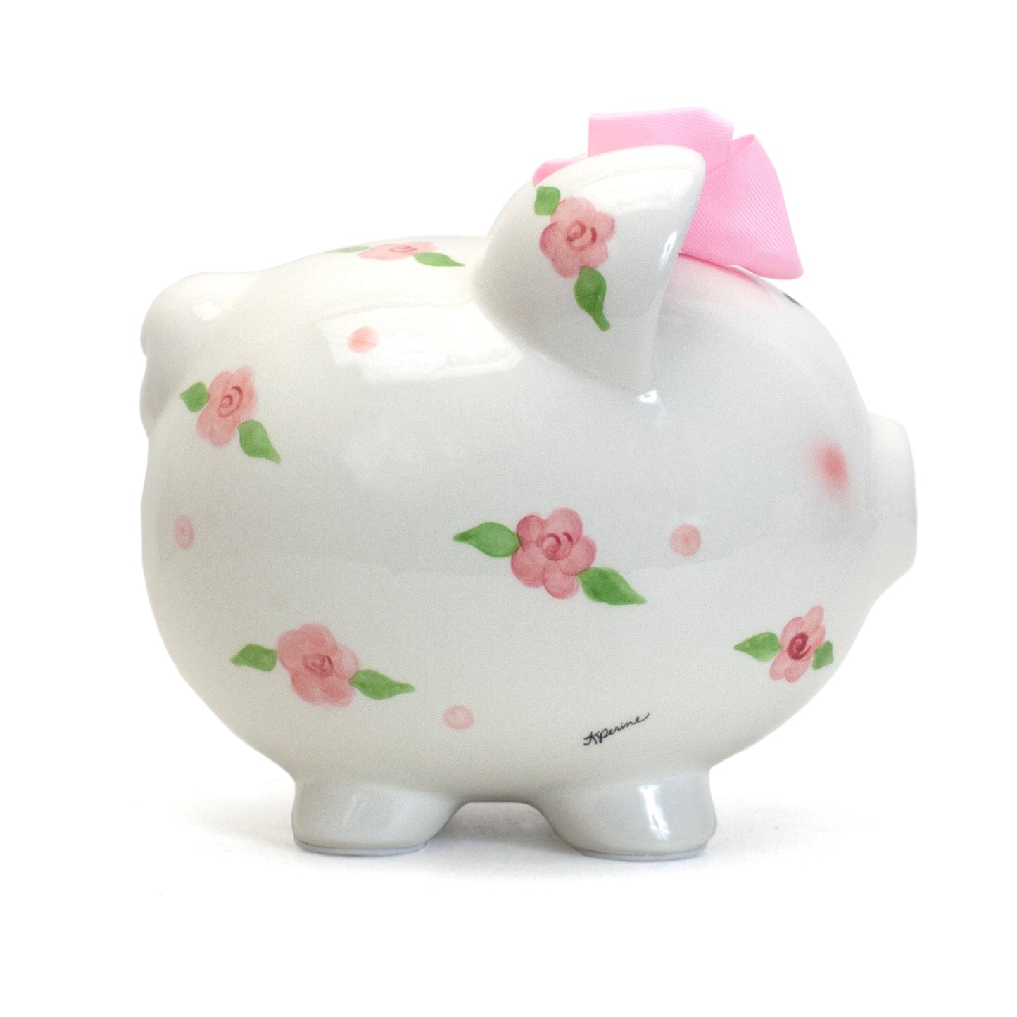 Side view of white ceramic piggy bank showing handpainted pink roses and green leaves with pink bow on head