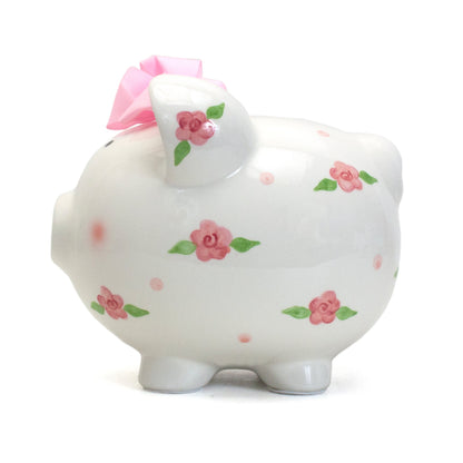 Back view of piggy bank highlighting the coin slot and floral design with pink bow