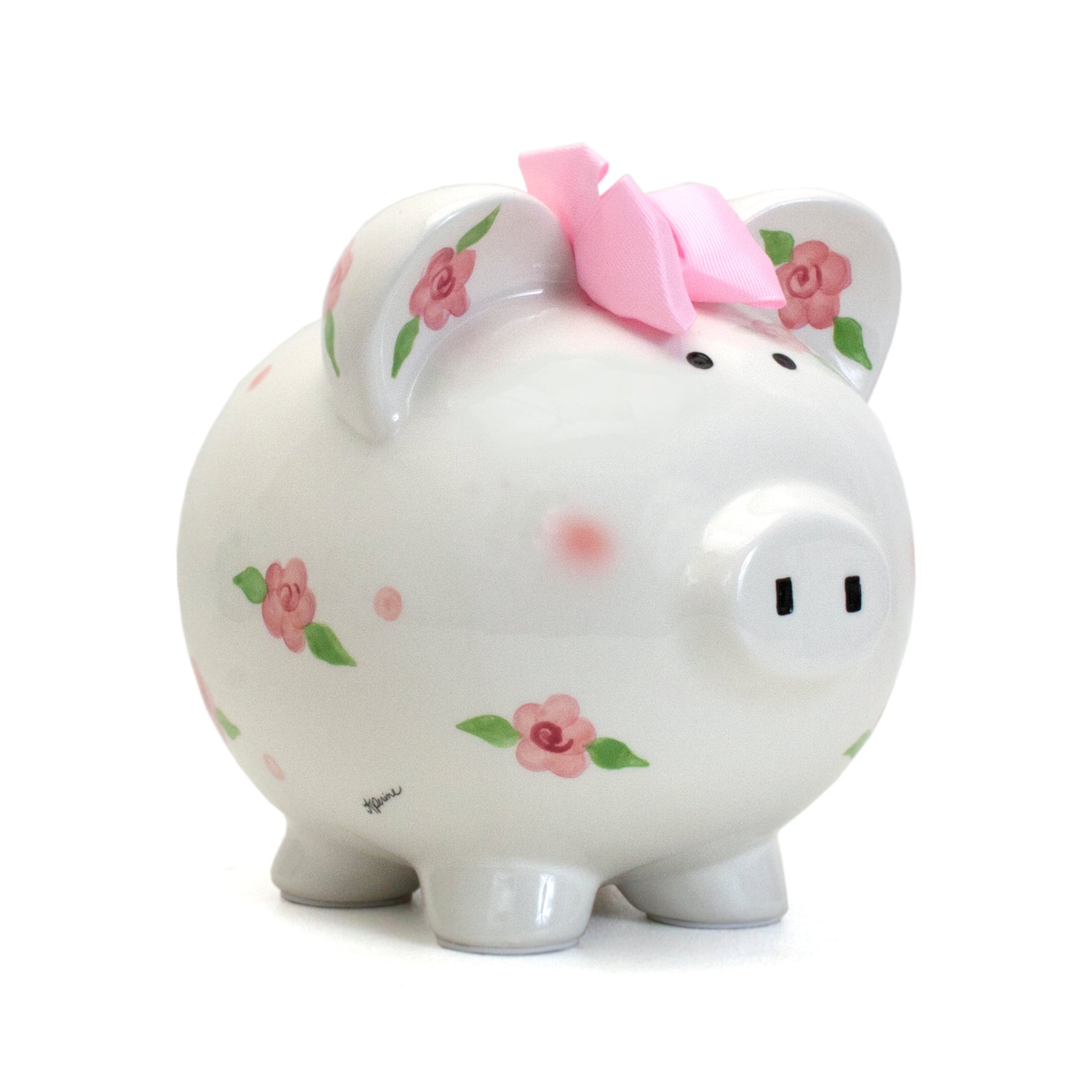 Angled view of white ceramic piggy bank with pink roses handpainted and pink bow on top