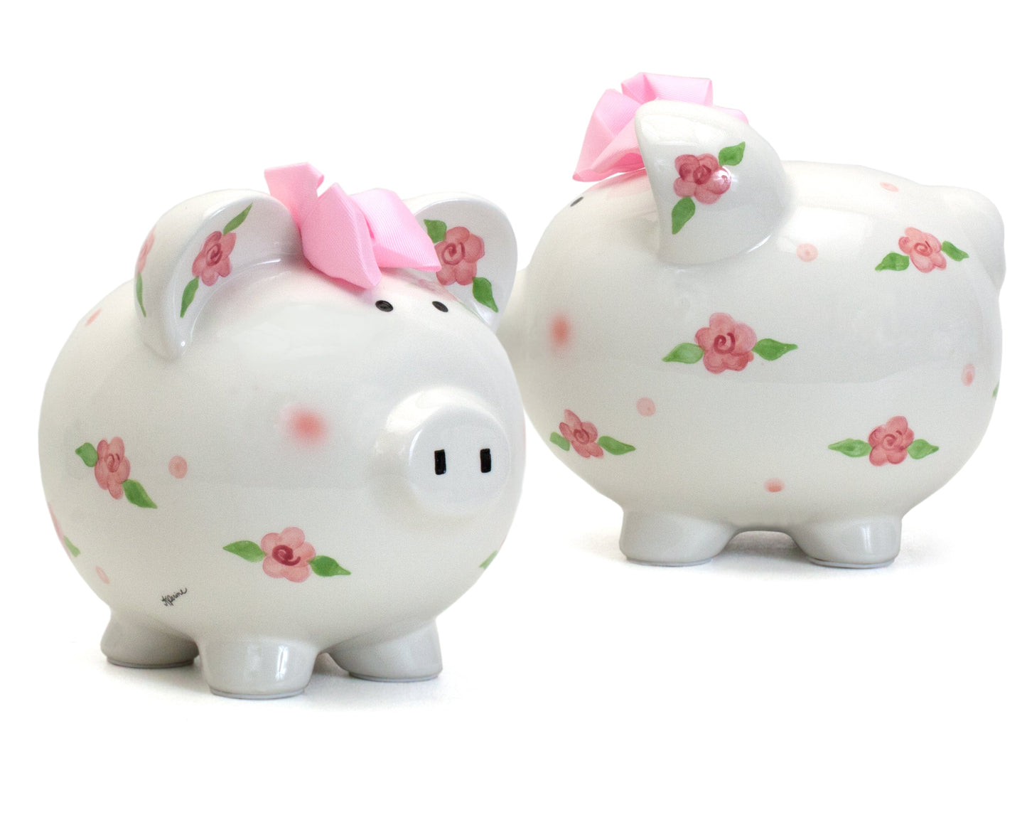 Close-up of piggy bank's glossy finish emphasizing pink floral handpainted details and fabric bow