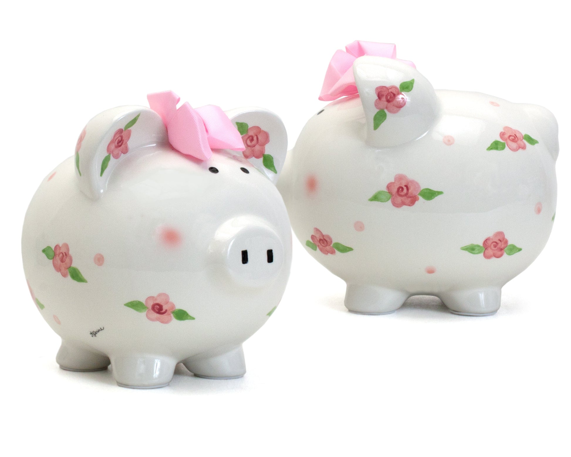 Close-up of piggy bank's glossy finish emphasizing pink floral handpainted details and fabric bow