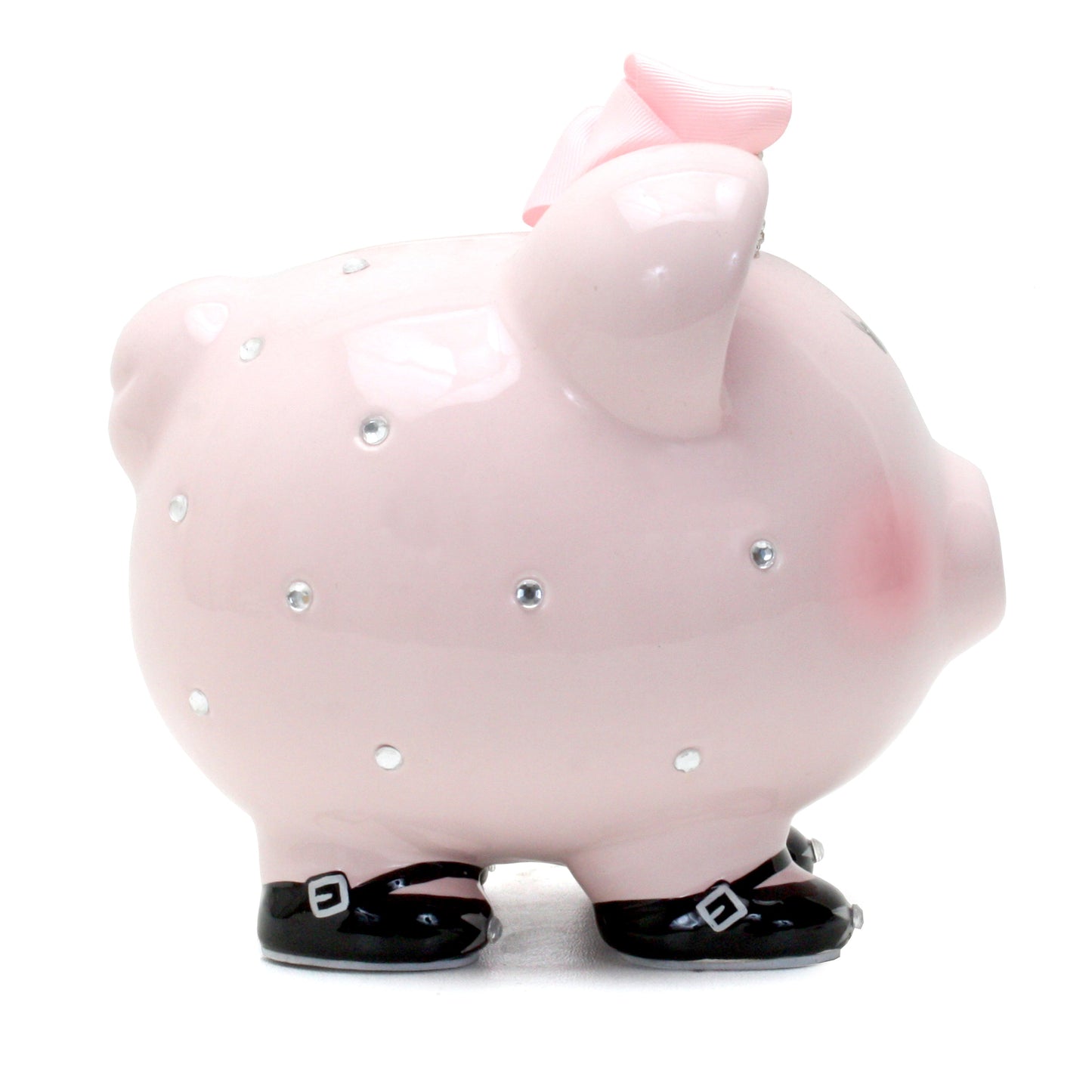 Side view showing piggy bank’s sparkling decorations and black shoes