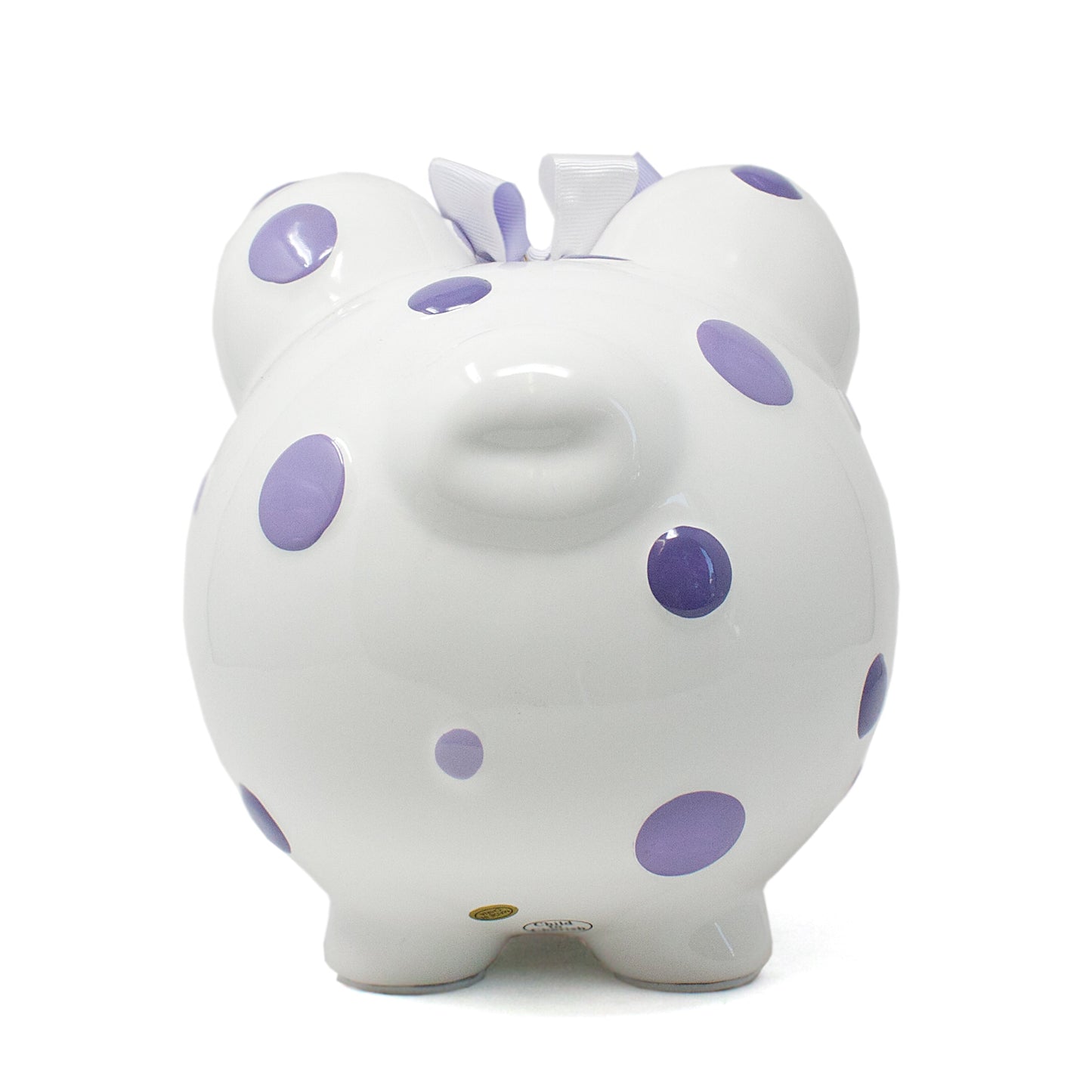 Back view of white ceramic piggy bank with purple polka dots and coin slot on top