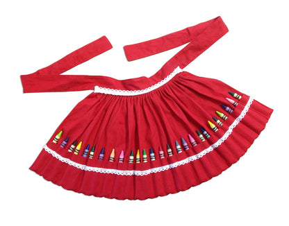 Red cotton apron with white lace trim featuring colorful crayons in individual pockets laid flat