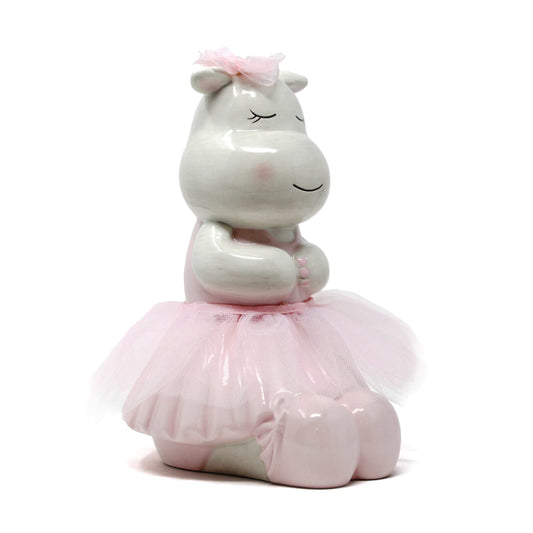 Handpainted ceramic piggy bank of a happy hippo wearing a pink tutu and ballet slippers with closed eyes and a pink bow