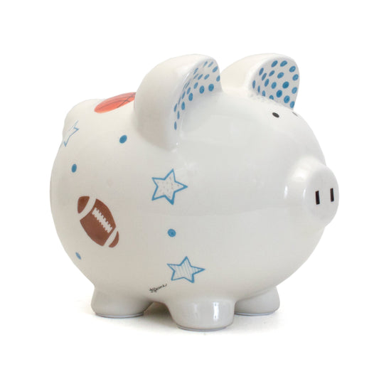 Side view of white piggy bank handpainted with football, basketball, stars, and blue dots