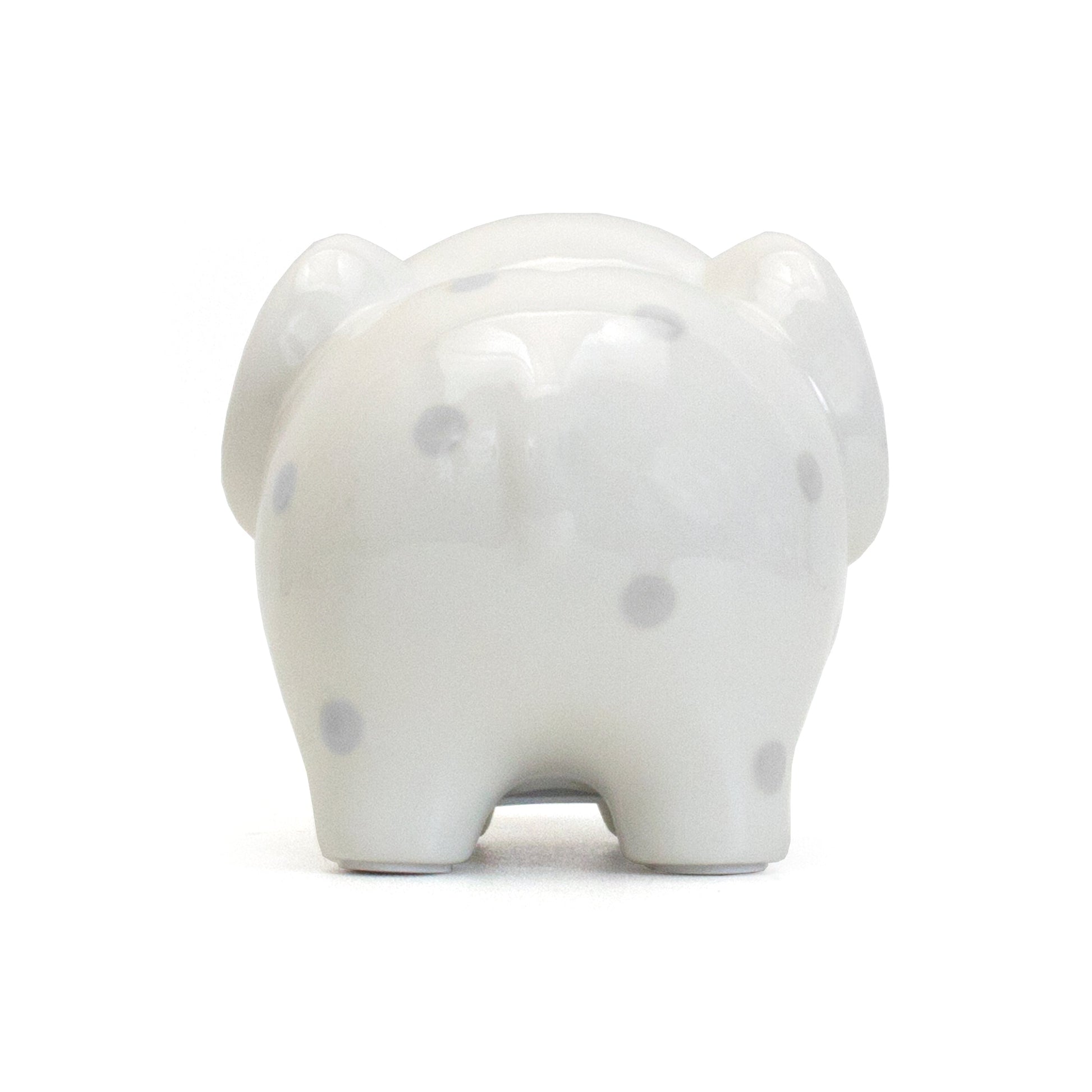 Rear close-up view of white ceramic elephant piggy bank standing on flat surface
