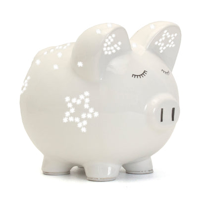 Side view of white ceramic piggy bank with star-shaped light perforations and closed eyes