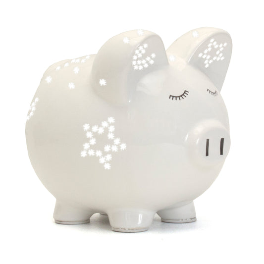 Side view of white ceramic piggy bank with star-shaped light perforations and closed eyes
