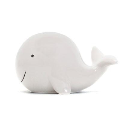 back view of white ceramic whale piggy bank with coin slot on tail side